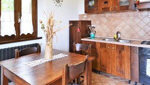 Une cuisine avec des meubles de rangement en bois, un pare-feu en carrelage, un évier et une cuisinière.