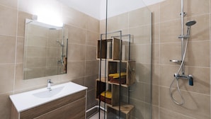 A modern bathroom with a glass shower enclosure, a white sink, and wooden shelves. - MAS SAINT LAURENT (Les Salles-du-Gardon)