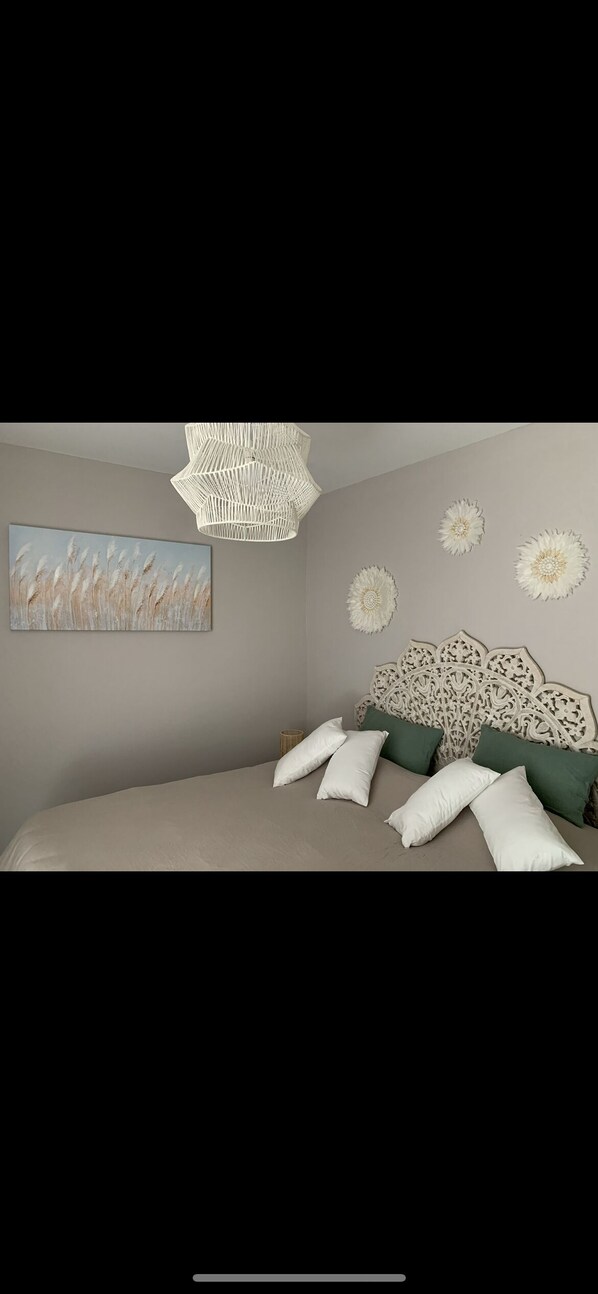 A bedroom with a bed, a hanging light fixture, and wall decorations. - MAS SAINT LAURENT (Les Salles-du-Gardon)