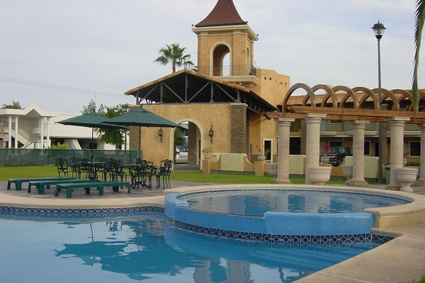 Alberca al aire libre, sombrillas en la alberca y camastros