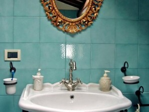 A bathroom with a white sink, a gold-framed mirror, and teal tiled walls. - Apartment for 4 People, Poppi (Poppi)