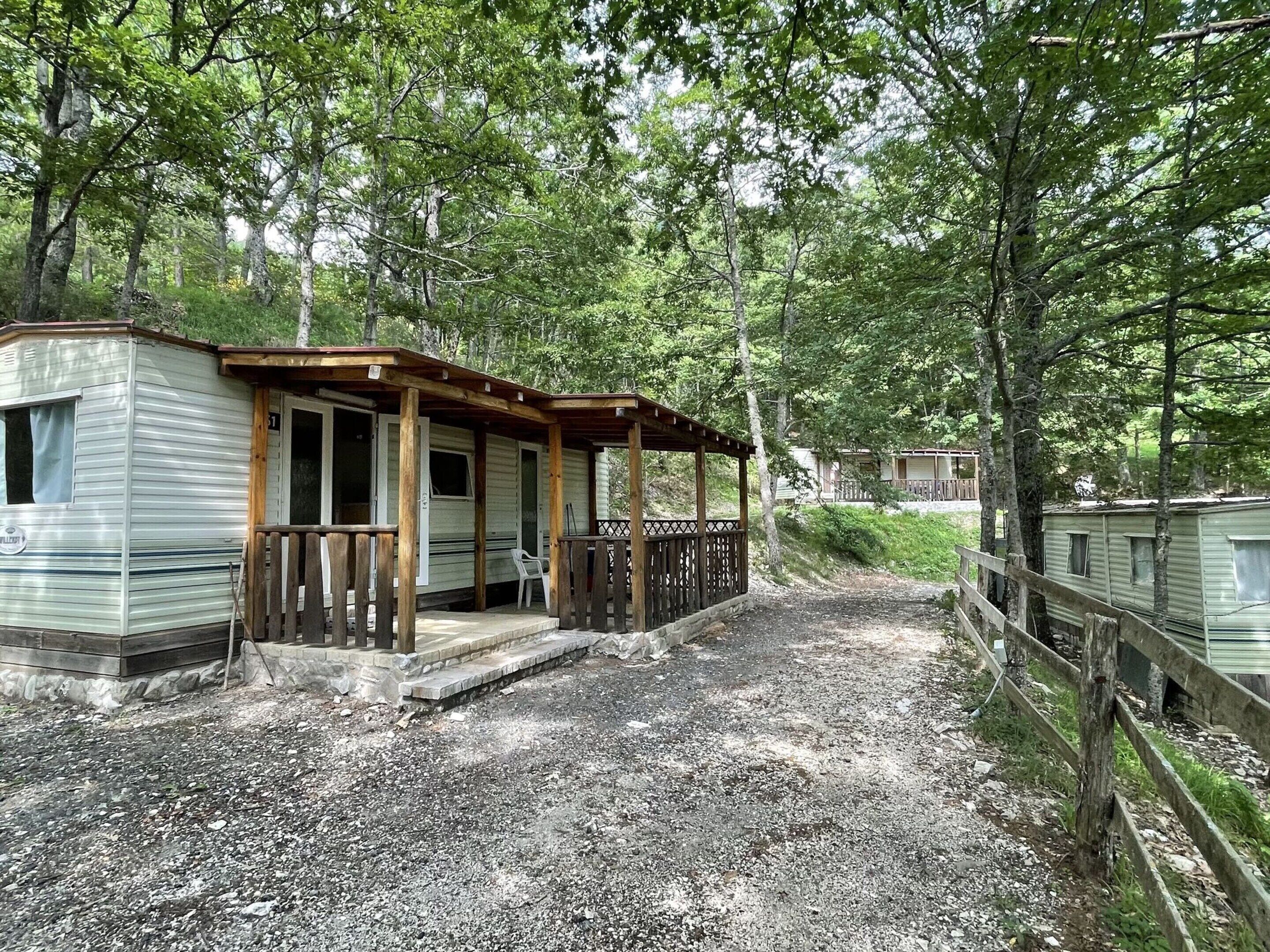 A mobile home with a porch and a gravel driveway.