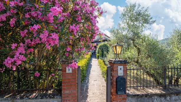 A pathway leading to a building with a brick entrance, a street lamp, and a sign with the number 9. - Scenic Retreat, Pergine Valdarno (Pergine Valdarno)