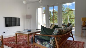 Un salon moderne avec un canapé, une table basse et un téléviseur fixé au mur.