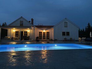 Une maison à deux étages avec une piscine à l’avant.