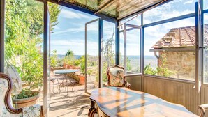 A conservatory with a glass ceiling, a dining table, and chairs. - Villa in Cortona With Pool (Cortona)