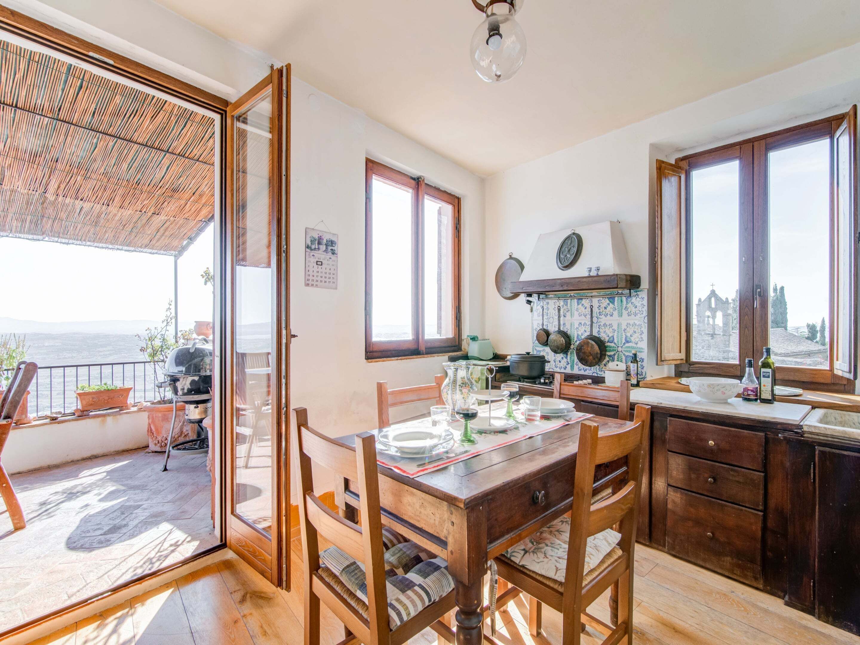Une cuisine avec vue sur la mer, des meubles en bois et un calendrier accroché au mur.