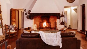 A cozy living room with a fireplace, wooden furniture, and a high ceiling. - Villa in Chianti With Pool & Tennis Court (Gaiole in Chianti)