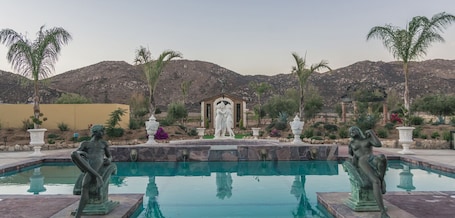 Una piscina al aire libre, sombrillas, sillones reclinables de piscina