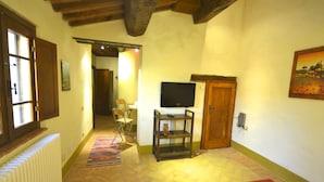 Ein gemütliches Wohnzimmer mit Kamin, Fernseher und Essbereich.