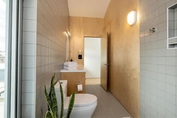 A modern bathroom with a toilet, sink, and mirror.