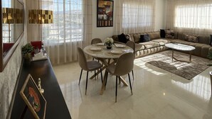 Un salon spacieux avec un coin repas, de grandes fenêtres et un design moderne.
