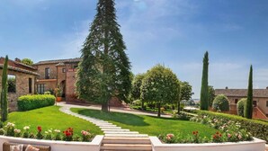 Un patio central con una escalera, rodeado de abundante vegetación y diversas plantas.