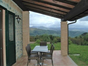 Enjoy al fresco dining or socializing in this serene outdoor space with a lush landscape view.