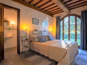 A bedroom with a bed, bedside tables, a mirror, and a window with curtains. - Peccioli Countryside Villa (Peccioli)