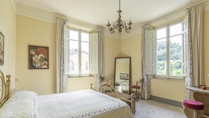 A bedroom with a large bed, a dresser, a mirror, and a window with curtains. - Holiday Home Tuscany With Pool Access (Montopoli in Val d'Arno)