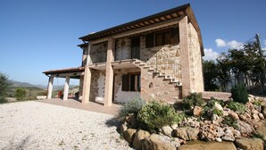 A stone house with a balcony, a staircase, and a gravel driveway. - Serene Living in a Stone Villa in Marche (Cagli)