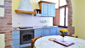 A kitchen with blue cabinets, a stove, and a window. - Apartment in Massa Marittima With Pool (Massa Marittima)