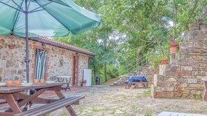 A rustic stone building with a stone staircase leading up to a wooden deck. - Apartment in Massa Marittima With Pool (Massa Marittima)