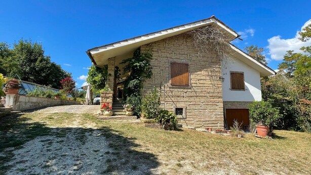 A two-story house with a stone facade and a white upper section. - Belvilla by OYO Grappolo D'uva (Esanatoglia)