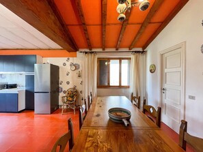 Un coin repas avec une table en bois, des chaises et une grande fenêtre.