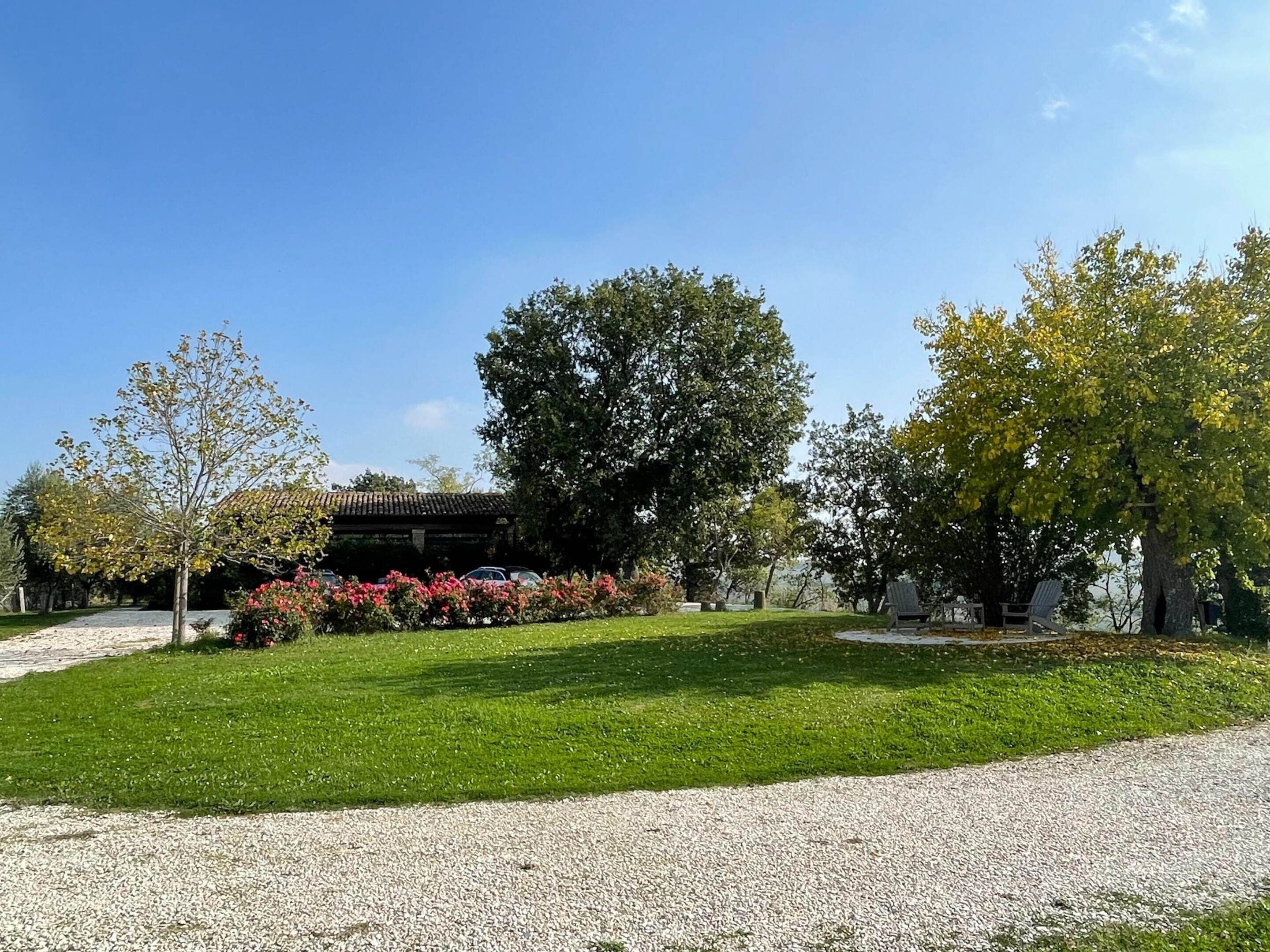 A well-maintained garden with a gravel path leading to a building with a tiled roof.