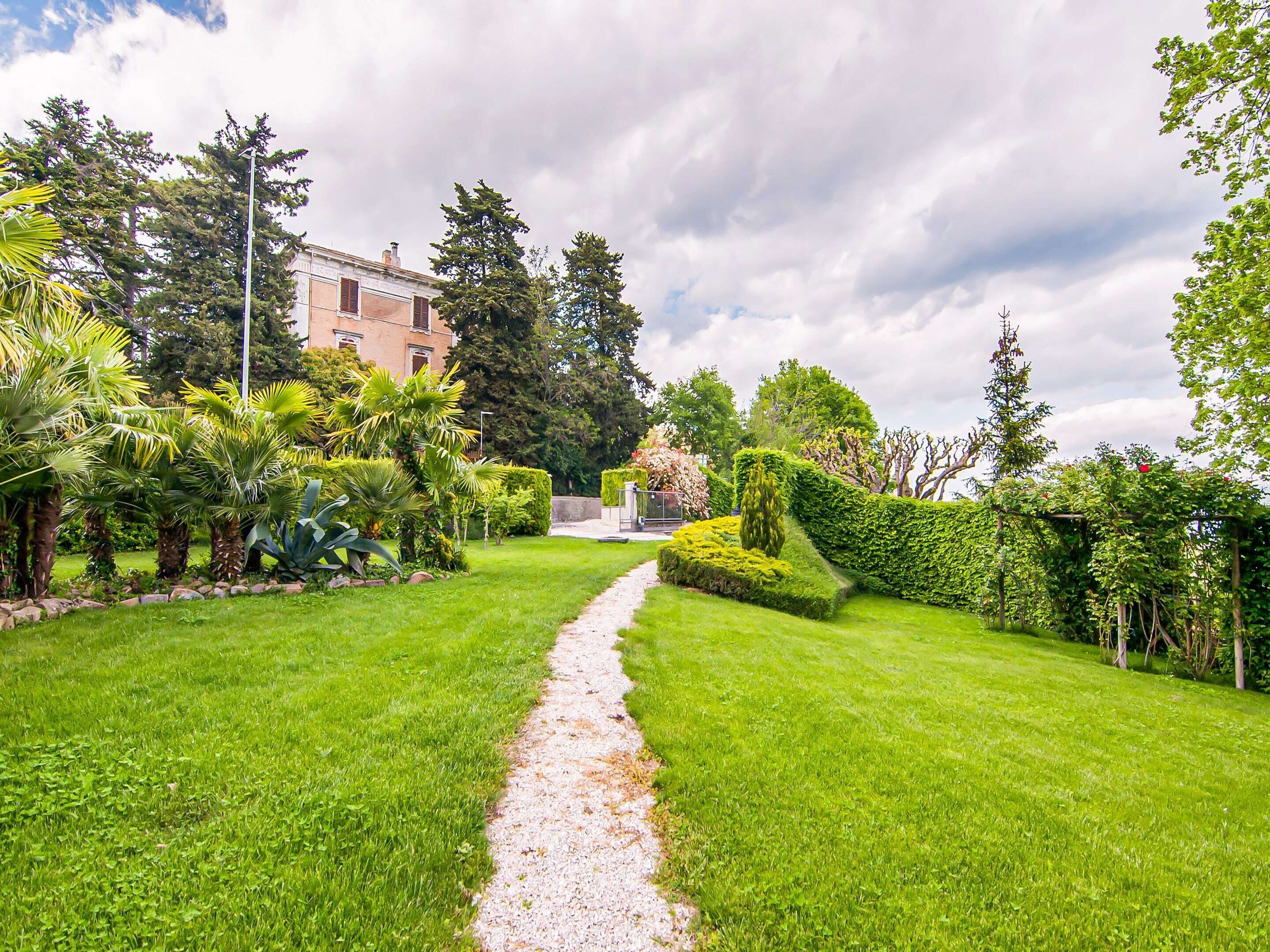 A well-maintained garden with a gravel path leading to a building.