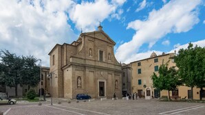 A historic church with a central dome and bell tower, surrounded by a paved square with trees and benches. - Belvilla by OYO Rose di Fratta 1 (Cupramontana)