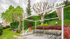 A covered patio area with outdoor seating and a children's play structure. - Belvilla by OYO Rose di Fratta 1 (Cupramontana)