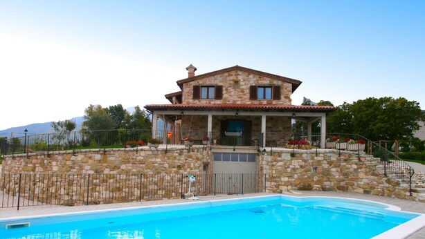 Una casa de piedra con piscina.