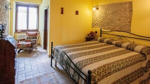 A bedroom with a bed, a chair, a dresser, and a window. - Belvilla by OYO Rossini (Urbania)