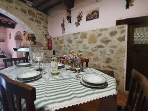A dining table set with plates, a wine bottle, and a vase of flowers. - Tranquility at Bellavista (Seggiano)