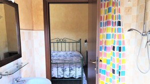 A bathroom with a bed, a sink, and a shower. - Farmhouse in Apecchio With Pool & Spa (Apecchio)