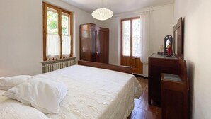 A bedroom with a bed, a wardrobe, a desk, and a mirror. - Pleasant Holiday Home With Whirlpool (Colli al Metauro)