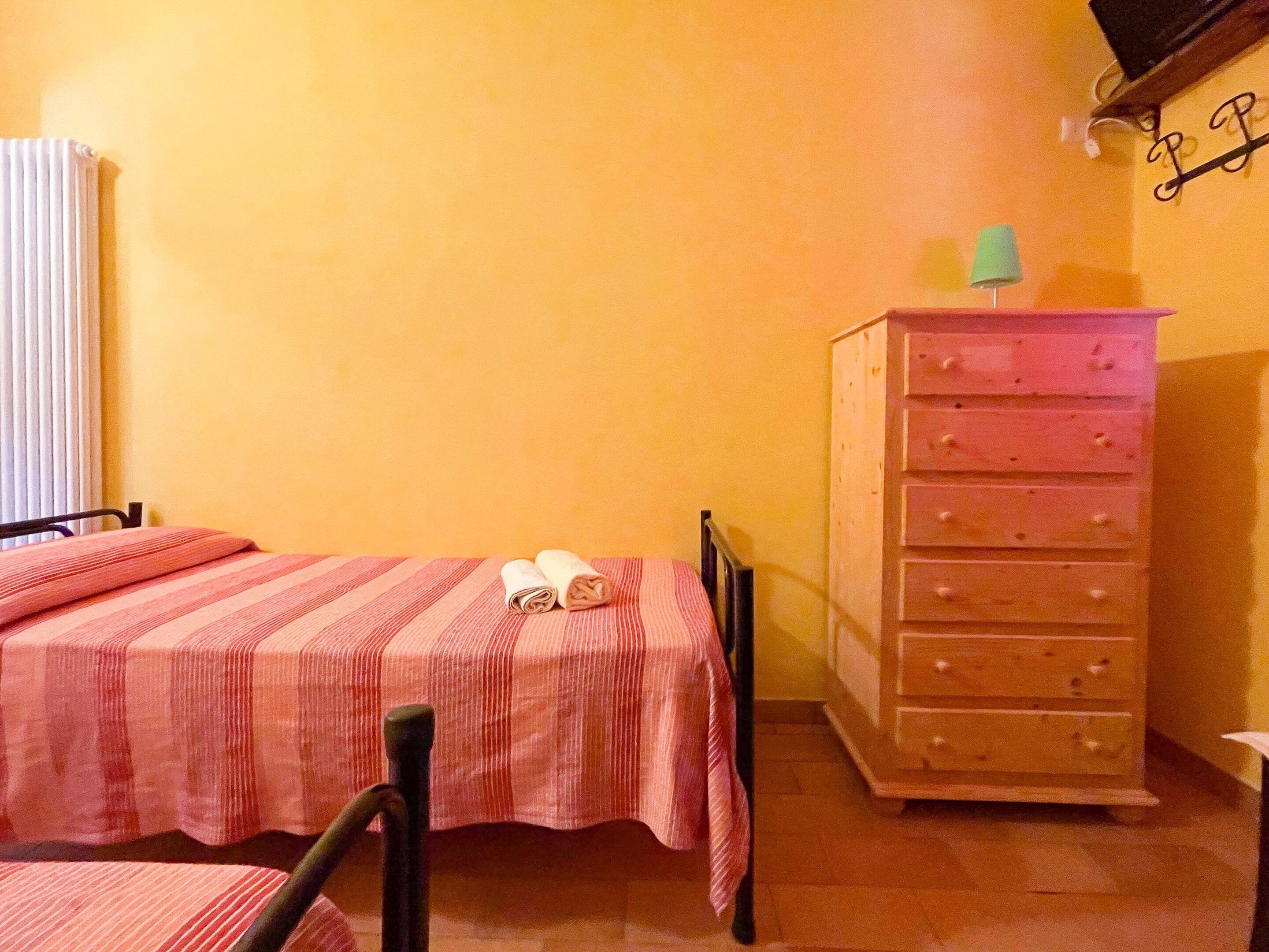 Ein Schlafzimmer mit einem Bett, einer Holzkommode und einer Heizung.