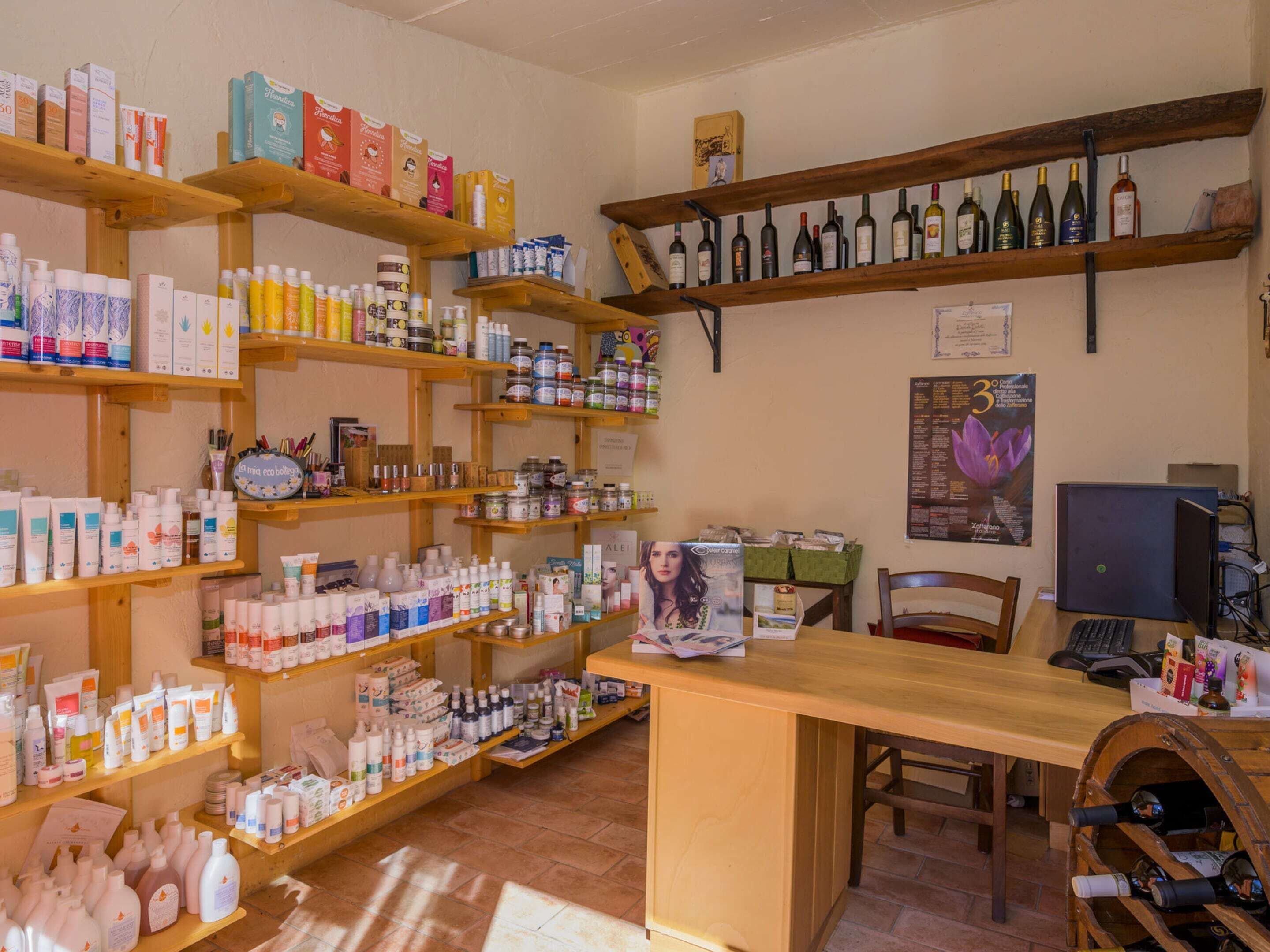 Ein Verkaufsraum mit Regalen voller verschiedener Produkte, einer Holztheke und einem Weinregal.