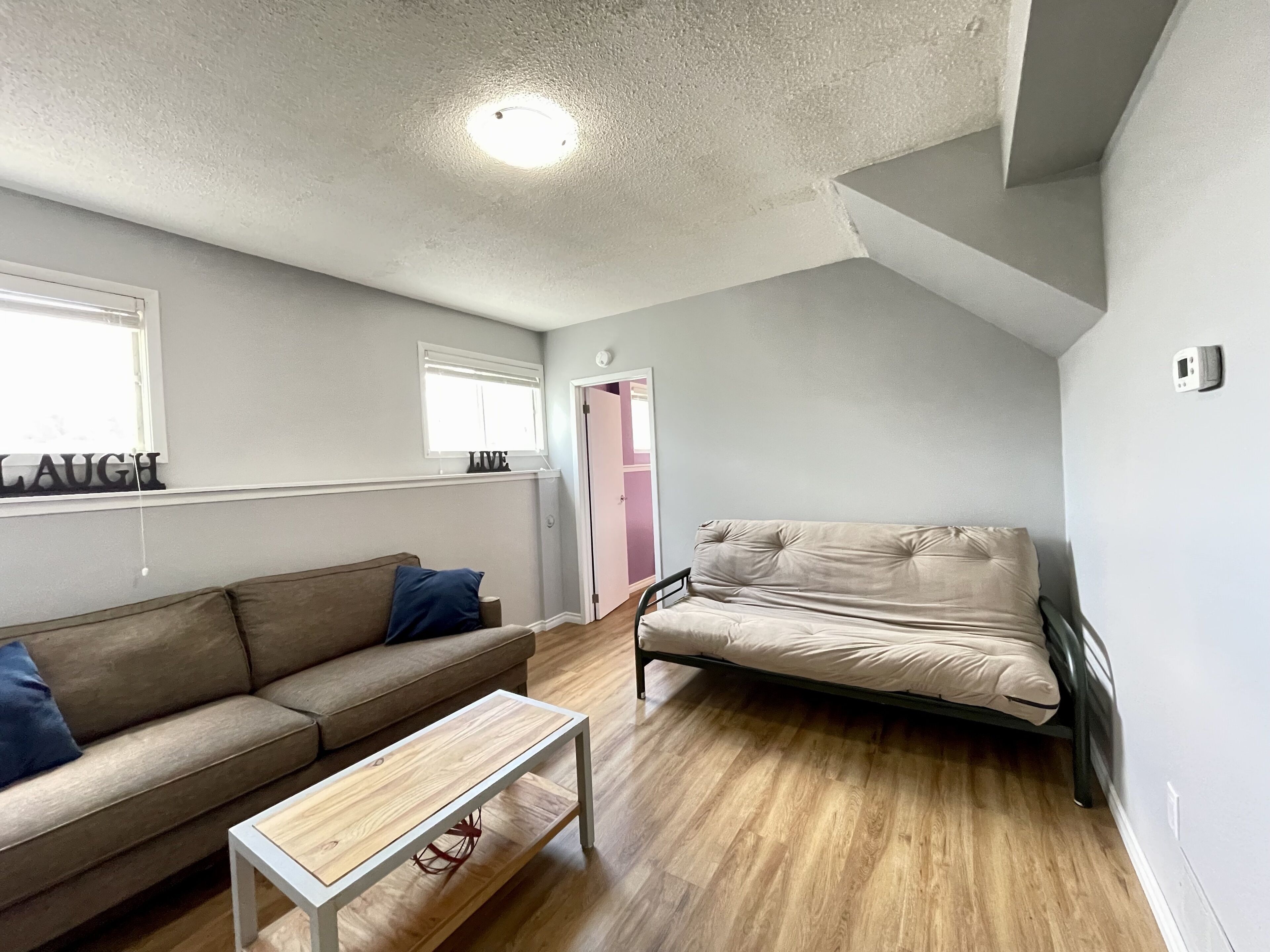 A modern living room with a sofa, a coffee table, and a bed.