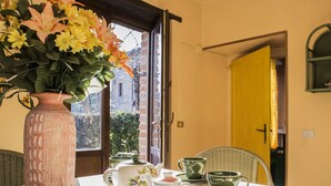 A table with a vase of flowers, a teapot, cups, and saucers. - Chalet in Monte Sibillini Park (Amandola)
