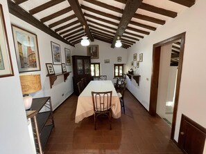 A dining room with a long table, chairs, and a cabinet. - Scenic Hideaway With Pool (Amandola)