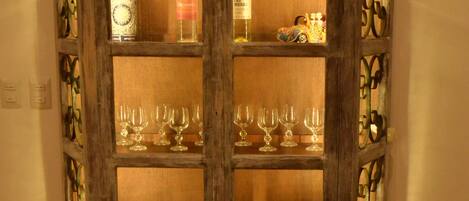 A wooden cabinet with glass doors, containing various glassware and dishes.