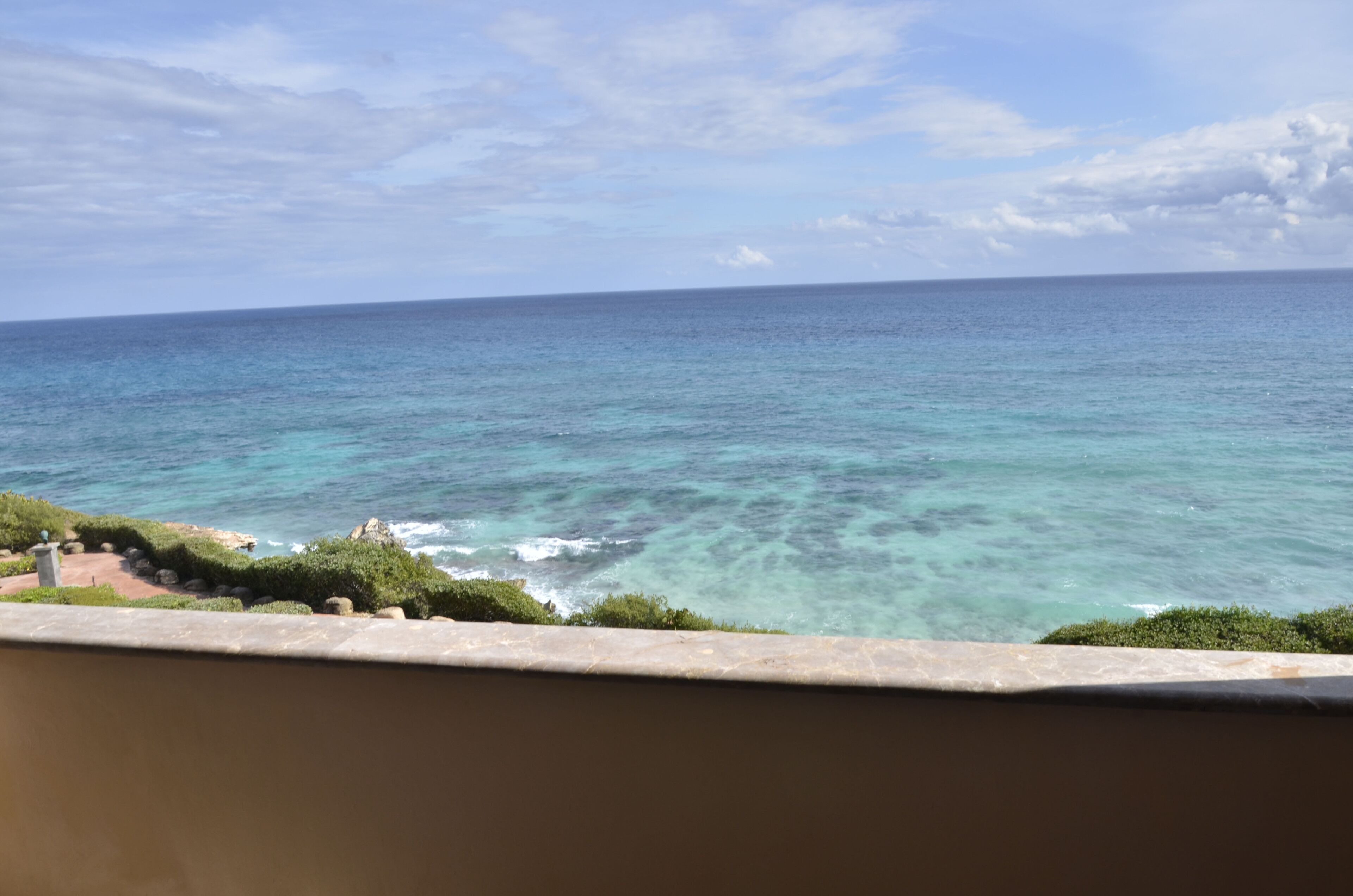 Vista dell'oceano da un balcone sotto un cielo sereno.