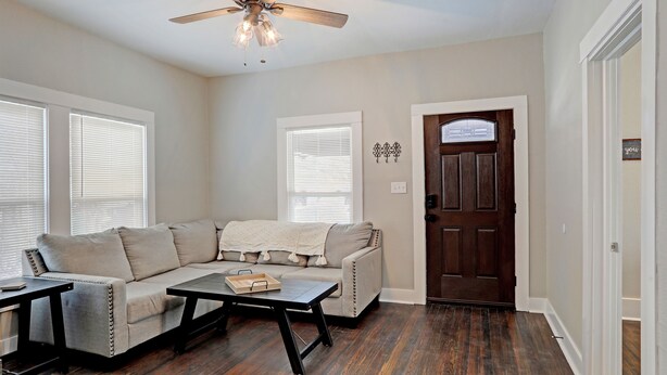 A living room with a sectional sofa, a coffee table, and a ceiling fan. - Blue Horizon Retreat- Near Downtown McKinney  (McKinney)
