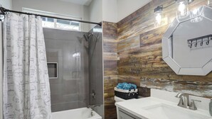 A modern bathroom with a shower, toilet, and sink. - Blue Horizon Retreat- Near Downtown McKinney  (McKinney)