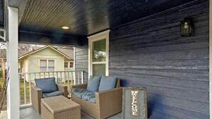 A porch with wicker furniture and a 'WELCOME' sign. - Blue Horizon Retreat- Near Downtown McKinney  (McKinney)