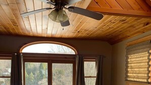 A bedroom with a large bed, a ceiling fan, a view through a glass door to an outdoor deck, and a window with blinds. - Private Lakefront with Dock! (MONGAUP VALLEY)