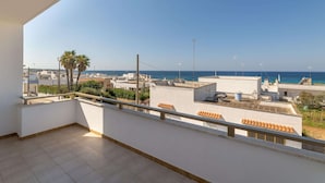 A balcony with a clear view of the sea and surrounding buildings. - Apartment Marina di Mancaversa by Ionian Sea (Taviano)