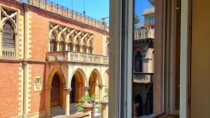 A view of a building with arched windows and a balcony, viewed from a window. - Holiday Home in Reggio Calabria Near Beach (Reggio Calabria)