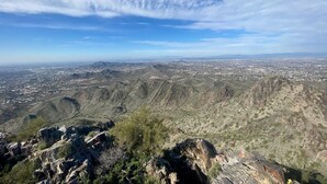Une vue panoramique d’un paysage montagneux avec une ville qui se dessine à l’horizon.