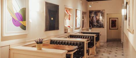 A restaurant with booth seating, artwork on the walls, and a patterned floor.