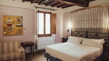 A bedroom with a bed, a chair, a radiator, a window with curtains, and a wall with a poster.